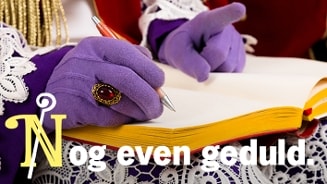 Hand van Sinterklaas met paarse handschoen schrijft in het grote boek, met de tekst 'Nog even geduld.'
