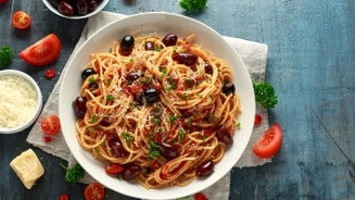 Pasta Puttanesca op wit bord