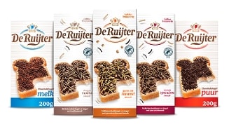 Vijf pakken De Ruijter chocoladehagelslag in de smaken melk, mokka, gezouten karamel, speculoos en puur, afgebeeld op boterhammen