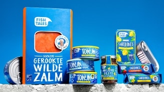 Assortiment van Fish Tales visproducten met gerookte wilde zalm, tonijn, ansjovisfilets en sardines, verpakt in opvallende blauwe verpakkingen tegen een blauwe achtergrond