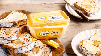 Becel margarinekuipje op tafel met gesneden brood en smeermes met margarine