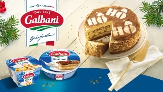 Galbani ricotta en mascarpone verpakkingen naast een tiramisu taart met decoratie 'Ho Ho' op de bovenkant, feestelijk gepresenteerd op een tafel met kersttakken en gouden bestek.