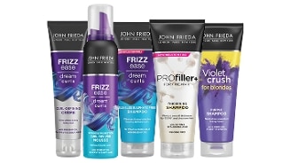 Vijf verschillende haarverzorgingsproducten van het merk John Frieda, waaronder Frizz Ease Dream Curls curl-defining crème, curl reviver mousse, SLS/SLES sulfate free shampoo, PROfiller+ thickening shampoo en Violet Crush for blondes purple shampoo.