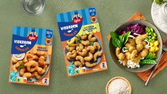 Twee verpakkingen Iglo Viskraam garnalen, één krokant gepaneerd en één met citroen en peterselie, naast een gerecht met deze garnalen, rijst, groenten en edamame boontjes.
