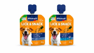 Twee zakjes Vitakraft Lick & Snack hondensnack van 60 gram, oranje-blauw ontwerp met afbeelding van een blije hond en informatie over toegevoegde vitamines en SmartTrain Complex.