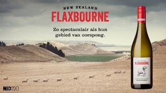 Een fles Flaxbourne Sauvignon Blanc Marlborough wijn uit Nieuw-Zeeland tegen een achtergrond van een heuvelachtig landschap met schapen.