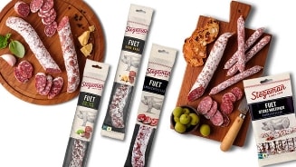 Fuet worstproducten van Stegeman, gesneden en verpakt op snijplanken met olijven en brood.
