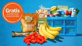 Gratis verantwoorde tussendoortjes actie bij Albert Heijn met onder andere bananen, cherrytomaten, Bites We Love Crunchy Corn, Barebells eiwitreep en diverse producten in een blauwe boodschappenkrat