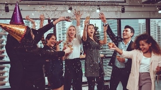 Feestvierende mensen gooien confetti in de lucht op een kantoorfeest.