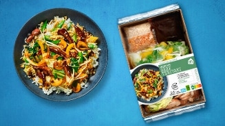 AH Japanese Beef Teriyaki maaltijdpakket met rijst, groenten en saus op een blauwe achtergrond.