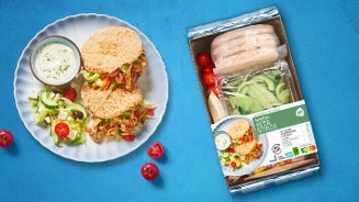 Griekse Pita Gyros maaltijdpakket van Albert Heijn met pita's, groenten en saus op een blauw bord.
