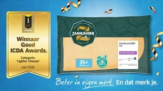 Plakje Zaanlander 35+ extra belegen kaas van Albert Heijn in verpakking naast een gouden award voor winnaar Goud ICDA Awards 2026 in de categorie 'Lighter Cheese', op een feestelijke blauwe achtergrond met linten.