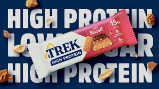TREK High Protein reep met Lotus Biscoff smaak op een achtergrond met de tekst ‘high protein low sugar’, omringd door stukjes koek en noten