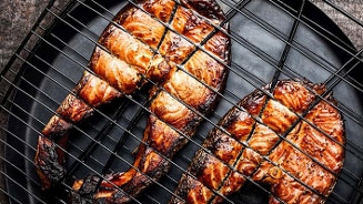 Gegrilde zalmmoten op een grillrooster.