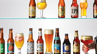 Assortiment van verschillende biermerken op een plank, waaronder Texels, Lagunitas, La Trappe en Chimay.