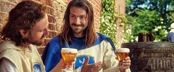 Affligem bierproeverij in een historische setting met mensen in middeleeuwse kledij.