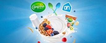 Ontbijtkom met Campina yoghurt, granola en vers fruit zoals aardbeien, blauwe bessen en bramen, op een blauwe achtergrond met Campina en Albert Heijn logo’s
