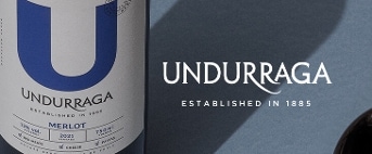 Fles Undurraga Merlot wijn uit 2021 op een blauwe achtergrond.