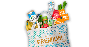 Tas met boodschappen waaronder Arla biologische melk, bananen, prei, paprika, komkommer en diverse voordeelaanbiedingen zoals "1+1 gratis" en "20% korting", met het label "PREMIUM" op de tas.