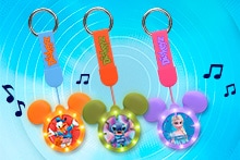 Sleutelhangers in de vorm van Mickey Mouse oren met afbeeldingen van Disney-personages, waaronder Donald Duck, Stitch en Elsa, voorzien van kleurrijke labels met "Diskeyz" en muzieknoten.