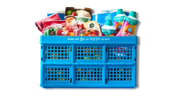 Blauwe Albert Heijn krat gevuld met diverse boodschappen zoals verse groenten, schoonmaakmiddel en toiletpapier