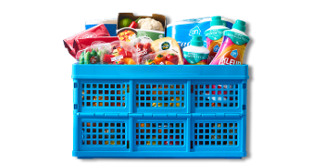 Blauwe boodschappenkrat gevuld met diverse Albert Heijn producten, waaronder verse groenten, fruitsalades, wasmiddel en keukenpapier.