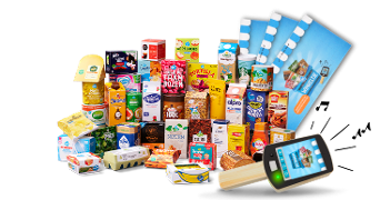 Assortiment van verschillende Albert Heijn boodschappen waaronder zuivel, sappen, broodbeleg, ontbijtproducten en een zelfscan apparaat op de voorgrond