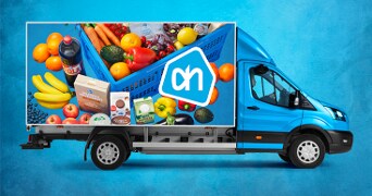 Blauwe Albert Heijn bezorgauto met versproducten zoals fruit, groente, melk, cola en andere boodschappen in een blauwe boodschappenkrat.