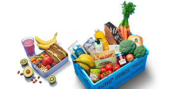 Albert Heijn boodschappenmanden met verschillende verse producten zoals groenten, fruit, brood, zuivel, sap, kaas, noten en een smoothie