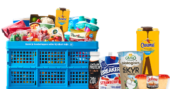 Blauwe Albert Heijn krat gevuld met diverse boodschappen, waaronder verse groenten, AH zuivelproducten, Parano kaasrasp, Chocomel drank, Arla biologische Skyr yoghurt, Melkunie Protein chocoladedrank, Melkunie Breaker yoghurt aardbei en Johma kip-samba salade.