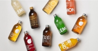 Assortiment van ChariTea en Lemonaid dranken in glazen flessen, diverse smaken.