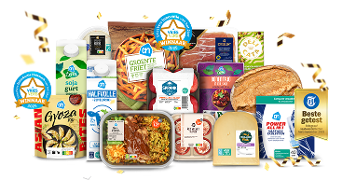 Assortiment van bekroonde Albert Heijn producten, waaronder halfvolle melk, sojayoghurt, groentefriet, maaltijden, kaas, brood en wasmiddel, versierd met confetti en winnaarsstickers voor ‘Vries Vers Winnaar 2025’ en ‘Beste getest’ awards.