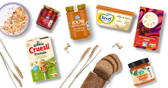 Verschillende ontbijtproducten, waaronder een kom muesli, Quaker Cruesli Protein met pistachenoten en zaden, AH jam, AH 100% Nederlandse honing, Becel margarine, DeliCata pure chocolade hagelslag, gesneden volkorenbrood en AH pompoen-mango spread.