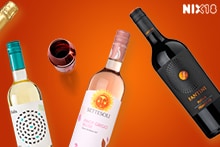 Verschillende flessen wijn en een glas rode wijn, geschikt voor consumenten van 18 jaar en ouder.