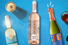Afbeelding van verschillende flessen wijn, waaronder rosé, witte wijn, rode wijn en een fles mousserende wijn. Succesmerken zoals Castano en Hey You zijn zichtbaar. Daarnaast staan er enkele glazen wijn.