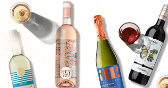 Afbeelding van verschillende flessen wijn, waaronder rosé, witte wijn, rode wijn en een fles mousserende wijn. Succesmerken zoals Castano en Hey You zijn zichtbaar. Daarnaast staan er enkele glazen wijn.