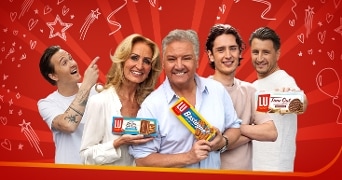 Mensen houden LU-producten vast, zoals Bastognekoeken en Time Out biscuits, tegen een rode achtergrond.