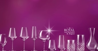 Glazen, wijnkoeler en karaf van Royal van Kempen & Begeer op een rij op een paarse achtergrond