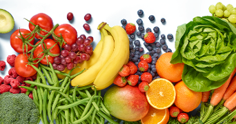 Verscheidenheid aan vers fruit en groenten, waaronder bananen, tomaten, druiven, bosbessen, aardbeien, mango, sinaasappels, avocado, sla, wortelen, broccoli, sperziebonen en frambozen.