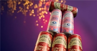 Drankblikjes van Fentimans gestapeld in verschillende smaken op een paarse achtergrond