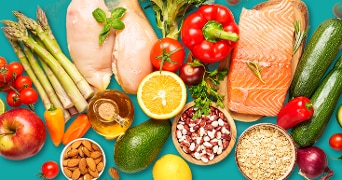 Verschillende gezonde voedingsmiddelen zoals zalmfilet, kipfilet, volkoren havermout, avocado, appels, noten, olie, citrusvruchten, paprika, cherrytomaten, asperges, courgettes, bonen en broccoli op een blauwe achtergrond