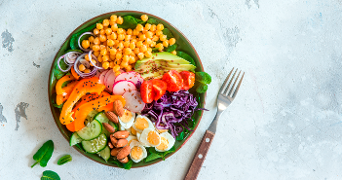 Bord gevuld met groenten, ei, noten en peulvruchten