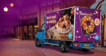 Albert Heijn vrachtwagen met kerstpromotie en Allerhande magazine-reclame op straat.