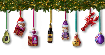 Kerstboom met kerstballen in de vorm van avocado, teddybeer met kerstmuts, stroopwafelblik, flesje Hertog Jan bier, teddybeer in paarse kleding, lachende peer, kreeft en kleurrijk koekje, versierd met lichtjes