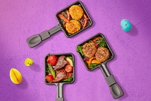 Gourmet grill gevuld met verschillende soorten vlees, vis, groenten en aardappelrösti, met extra pannetjes met gebakken hapjes.