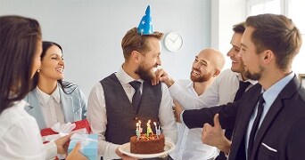 Zakelijke verjaardag viering met taart, brandende kaarsjes en cadeau's
