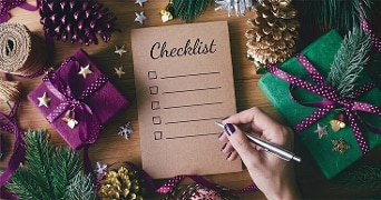 kersttafel met cadeautjes en decoratie met in het midden een checklist