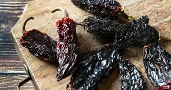 Gedroogde chilipepers op een houten plank