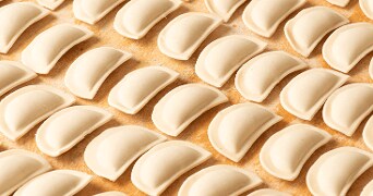 Verse, ongebakken ravioli op een houten ondergrond, netjes in rijtjes gerangschikt