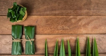 Pandanbladeren op een houten tafeltop met diverse plooien en rangschikking.